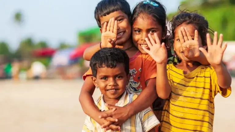 a group of children smiling and waving